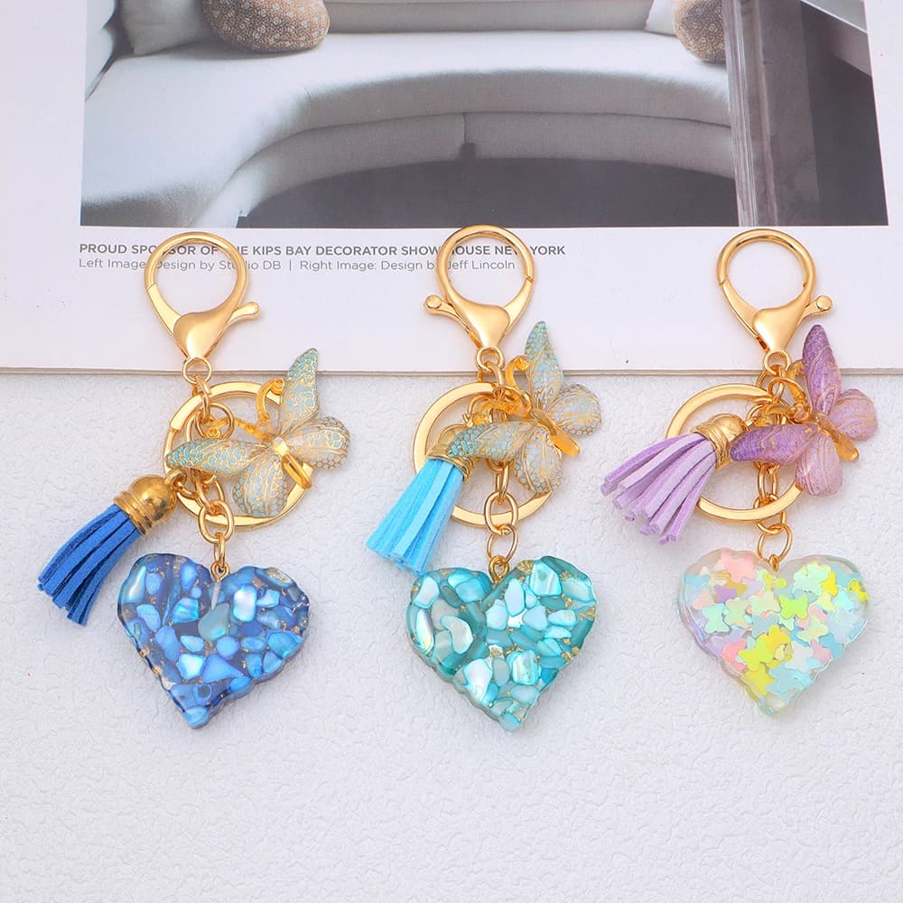 Porte-clés en forme de cœur en résine rempli de paillettes brillantes, pendentif bohème avec pompon papillon pour femmes, accessoires de sac à main, bijoux cadeau